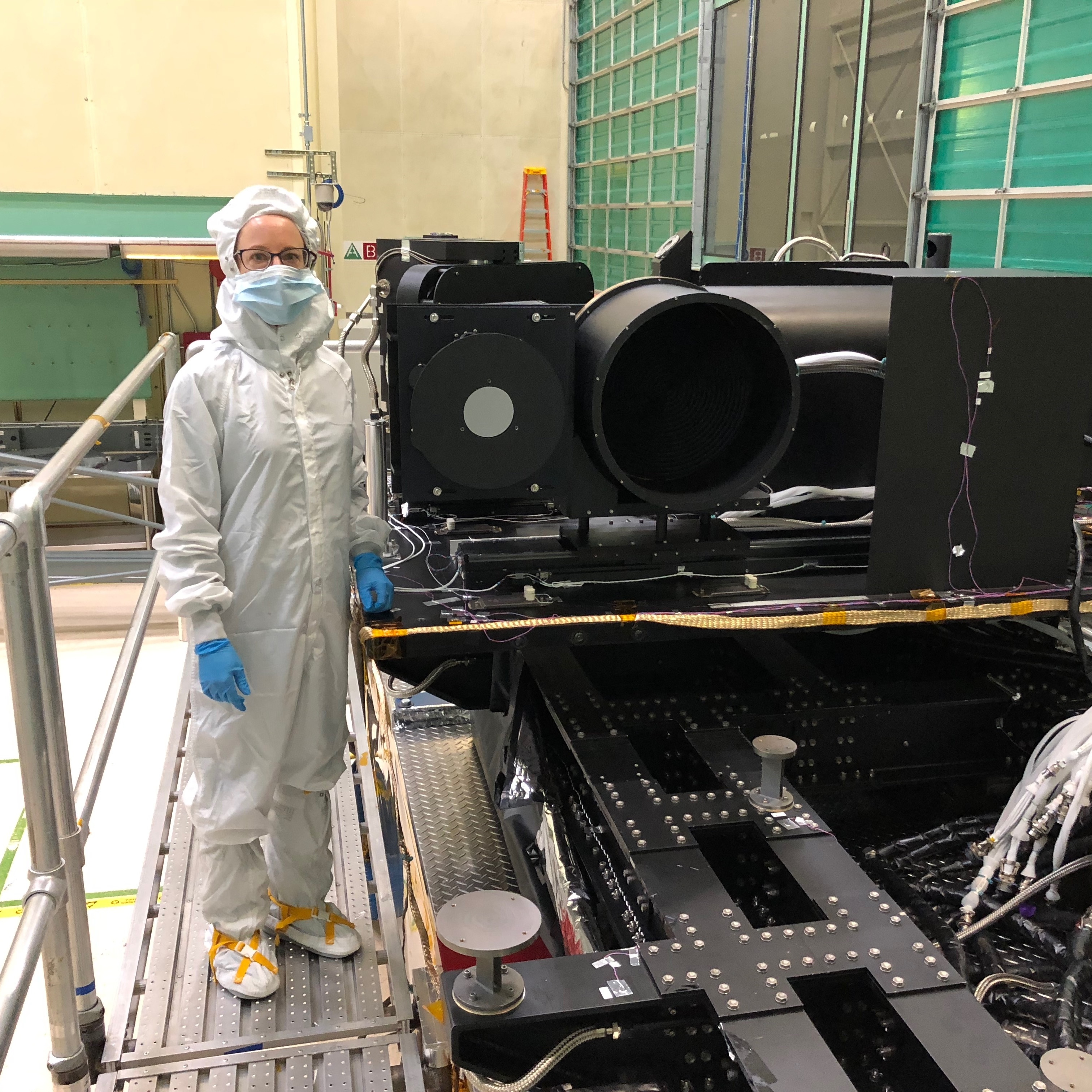 Amy Simon (L'Ralph DPI) with the ground equipment that will be used to test and calibrate the L'Ralph instrument in the thermal vacuum chamber at Goddard Space Flight Center.  Thermal vacuum testing simulates the conditions the instrument will experience in flight.